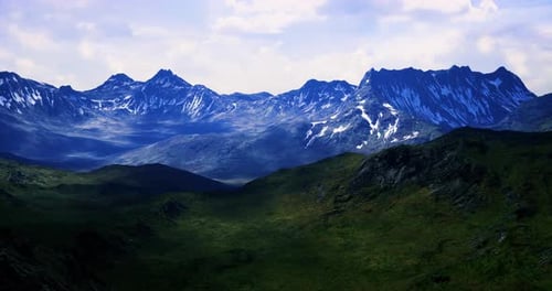Majestic Mountain Range with Snow Capped Peaks in Lush Valley During Daylight