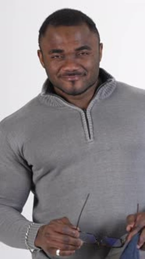 Portrait of african athlete in sweater. Black skinned guy is standing in studio and smiling.