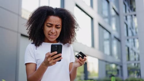 Woman Reacts in Shock Holding Phone and Credit Card