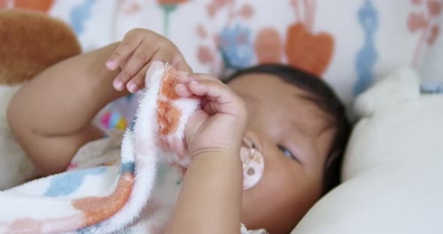 Baby enjoying comforting blanket at home sleepy moment lifestyle cozy environment close-up view