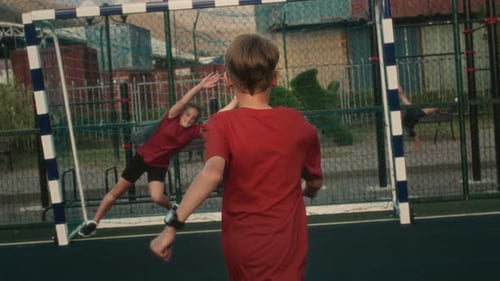 Boy Attacker Aims for Goal and Kicks Ball with Precision Securing Successful Outcome