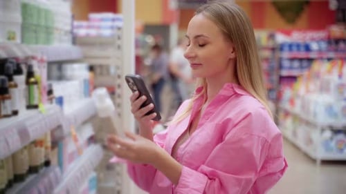 Customer Using Smartphone Scanning Product in Supermarket