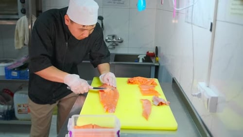 Chef Slices Salmon Fillet in Restaurant Kitchen