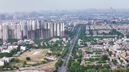 Aerial drone shot of Noida roads with metro rail tracks running parallel.