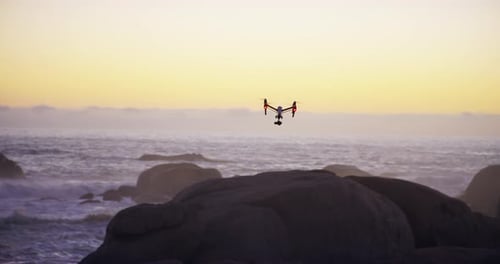 4k video footage of a drone flying across the beach at sunset