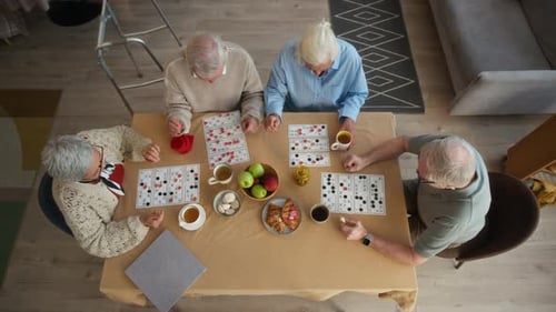 Overhead View of Seniors Enjoying Bingo and Snacks