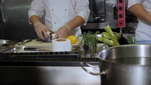 Dos chefs con uniformes blancos trabajan en una gran cocina profesional