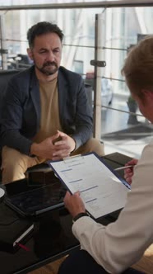 Businessmen Discussing Contract Documents in Bright Modern Office