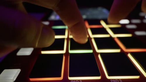 Close Up Hands Playing Beat On Glowing Drum Machine Pads In Studio