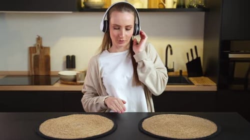 Woman Dancing to Music with Headphones in Kitchen