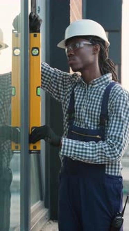Construction Worker Using Spirit Level on Window Frame