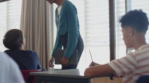 In school, teacher smiling and interacting with students in classroom setting