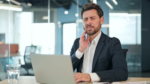 Distressed Businessman with Toothache in Office