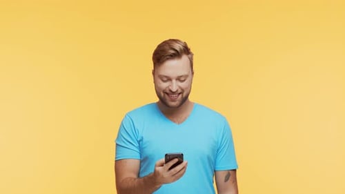 Man Using Smartphone on Yellow Background