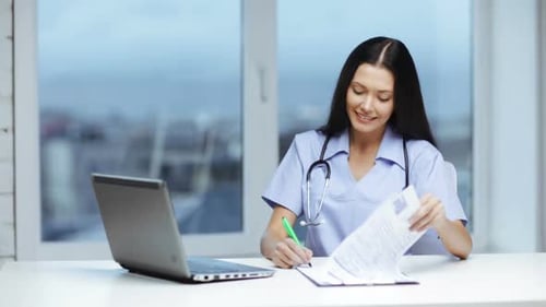Healthcare, Medical and Technology Concept - Female Doctor or Nurse with Laptop