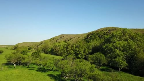 Aerial Footage of Camera Flying Over the Picturesque Valley Green Fields and Hills Rocky Cliffs and