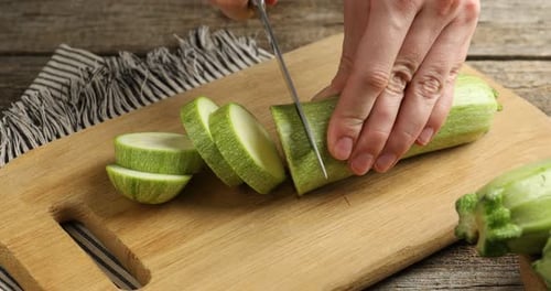 Cutting Fresh Zucchini on Wooden Cutting Board
