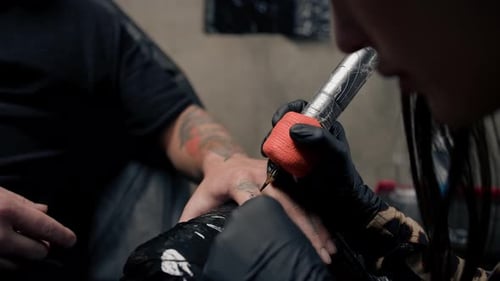 Close-up - a needle penetrates the skin, tattoo, tattoo studio