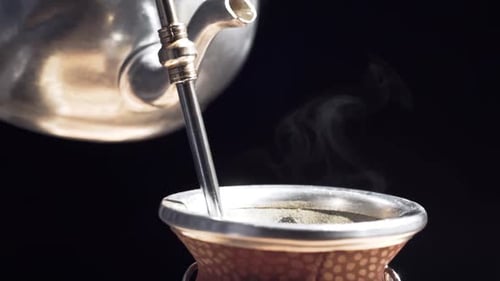 Pouring water to make argentine green tea.