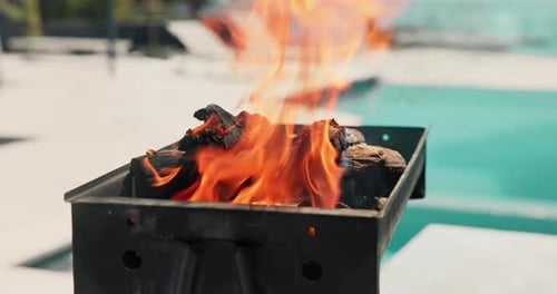 Empty, pool and bbq with flame in backyard for party, holiday and lunch on weekend outdoor