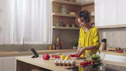 Young Woman Prepares Salad in Kitchen
