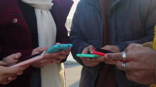 Unrecognizable Diverse People Using Mobile Phones Standing Together Outdoors