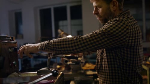 Concentrated Mature Industrial Man Working Indoors in Metal Workshop