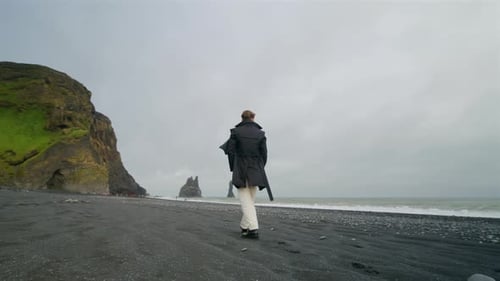 A Young Man Standing at the Famous Reynisfjara Black Sand Beach Located in Iceland