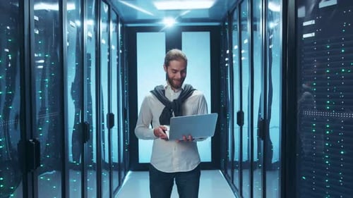Young Adult Man With Laptop in Server Room