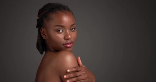 Shoulder, skincare and smile with face of black woman in studio for beauty