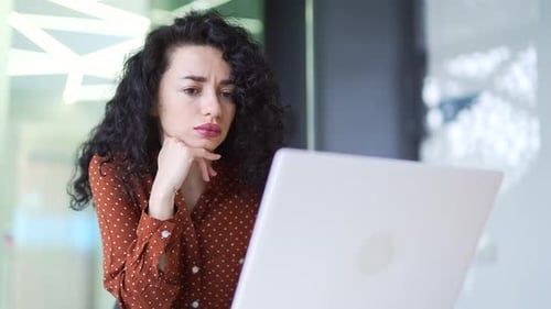 Thoughtful serious brunette businesswoman is thinking about solving a problem while working