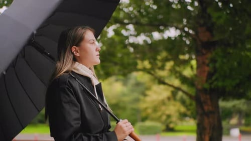 Thoughtful Woman with Umbrella on a Rainy Day