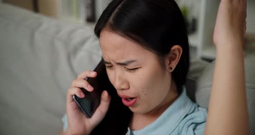 Worried Woman Talking on Mobile Phone Indoors