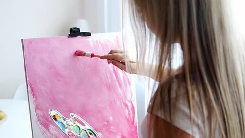 Woman Painting with Pink Paint on Canvas Indoors