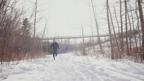 Slow Motion Of Male Runner Trail Running In Winter