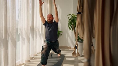 adult man with a beard doing exercises for stretching the muscles of the body doing sports yoga