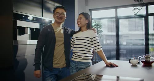 Couple smiling in a modern kitchen interior