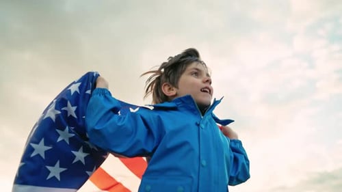 Child Waves American Flag Proudly to the Sky