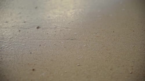 Waves washing sandy beach in slow motion