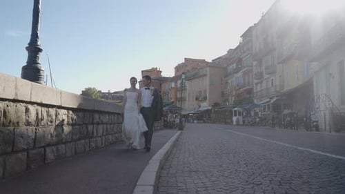 Beautiful newlyweds walking in ancient city. Action. Couple of newlyweds