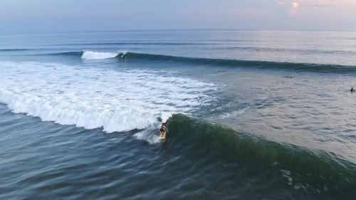 Aerial: beautiful Mexican surfing destination, surfer riding wave at sunset