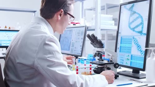Scientist Analyzing Sample Under Microscope in Laboratory