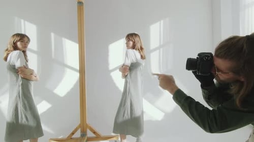 Photographer Capturing Image of Woman Posing in front of Mirror in Studio