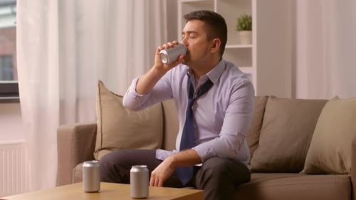 Man in Shirt and Tie Drinking a Can