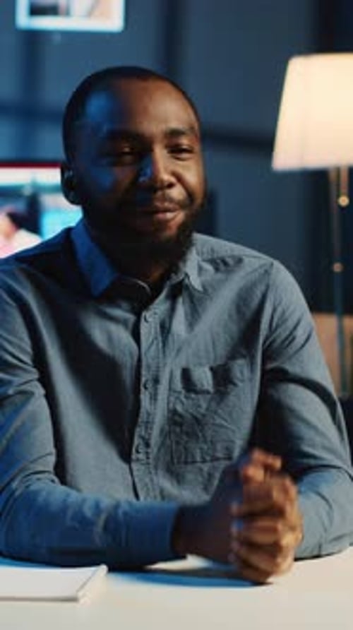 Young Adult Man Talking at Desk in Office