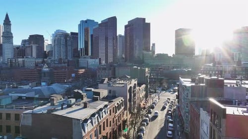 Boston’s skyline with sunlight reflecting off skyscrapers. Historic buildings line Hanover Street in
