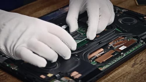 Ein Techniker in weißen Handschuhen ersetzt RAM-Boards in einem modernen und leistungsstarken autorisierten Laptop-Kundendienst