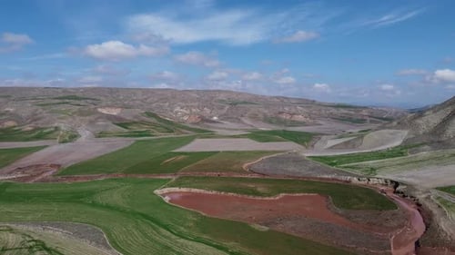 Aerial view of mountains and fields in vast terrain 4K