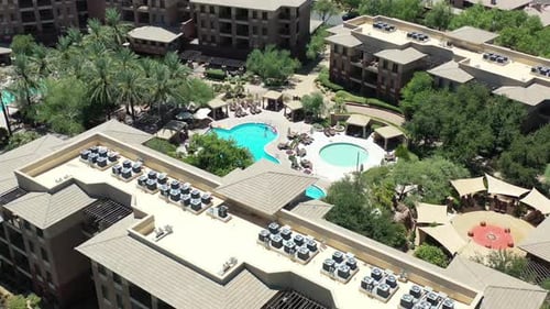 A drone approaches and pans down to reveal a stunning luxury pool at a fabulous destination resort.