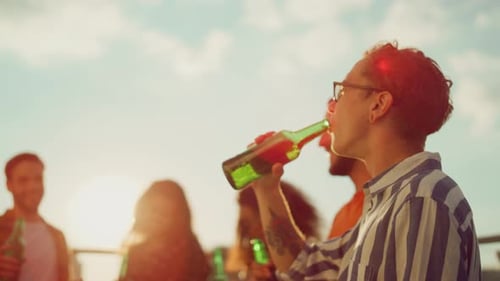 Group of Cheerful People Dancing at Terrace Party. Multiracial Happy Friends Clinking